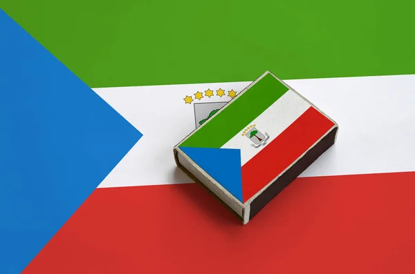 赤道几内亚国旗被描绘在一个火柴盒上 位于一个大旗上 — 图库照片