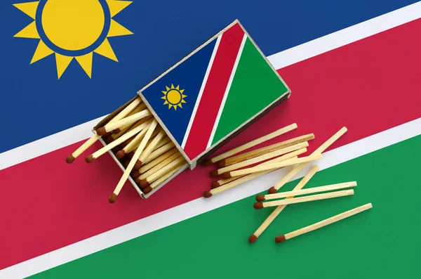 Namibya bayrak bir kibrit kutusu içinden birkaç sonbahar eşleşir ve büyük bir bayrak üzerinde yatıyor açık gösterilir.