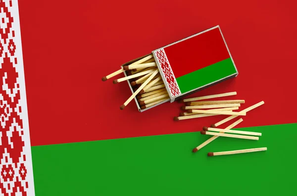 Belarus flag is shown on an open matchbox, from which several matches fall and lies on a large flag. — Stock Image Belarus Flag Shown Open Matchbox Which Several Matches Fall Lies Royalty Free Stock Images