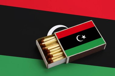 Libya bayrağı açık bir kibrit kutusu içinde gösterilen hangi dolu maçlar ve büyük bir bayrak üzerinde yatıyor.