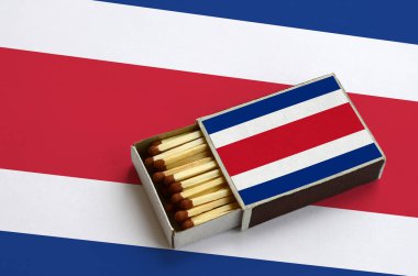 Kosta Rika bayrak açık bir kibrit kutusu içinde gösterilen hangi dolu maçlar ve büyük bir bayrak üzerinde yatıyor.