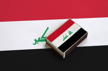 Irak bayrağı üzerinde büyük bir bayrak yatıyor bir kibrit kutusu üzerinde resimde.