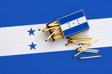 Honduras bayrağı bir kibrit kutusu içinden birkaç sonbahar eşleşir ve büyük bir bayrak üzerinde yatıyor açık gösterilir.