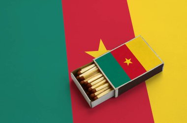 Kamerun bayrağı açık bir kibrit kutusu içinde gösterilen hangi dolu maçlar ve büyük bir bayrak üzerinde yatıyor.