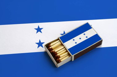 Honduras bayrağı açık bir kibrit kutusu içinde gösterilen hangi dolu maçlar ve büyük bir bayrak üzerinde yatıyor.