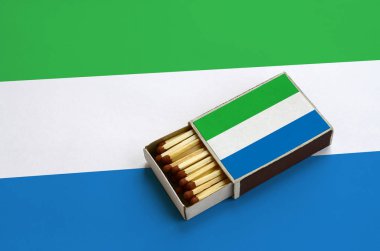 Sierra Leone bayrak açık bir kibrit kutusu içinde gösterilen hangi dolu maçlar ve büyük bir bayrak üzerinde yatıyor.