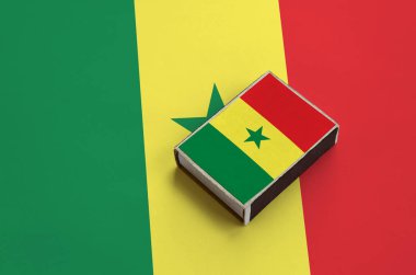 Senegal bayrağı üzerinde büyük bir bayrak yatıyor bir kibrit kutusu üzerinde resimde.