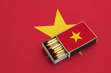 Vietnam bayrağı açık bir kibrit kutusu içinde gösterilen hangi dolu maçlar ve büyük bir bayrak üzerinde yatıyor.
