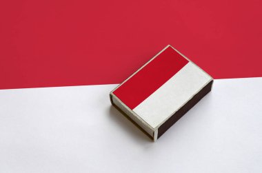 Monaco bayrağı üzerinde büyük bir bayrak yatıyor bir kibrit kutusu üzerinde resimde.