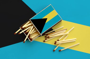 Bahamalar bayrağı bir kibrit kutusu içinden birkaç sonbahar eşleşir ve büyük bir bayrak üzerinde yatıyor açık gösterilir.