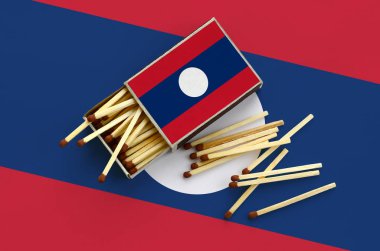 Laos bayrağı bir kibrit kutusu içinden birkaç sonbahar eşleşir ve büyük bir bayrak üzerinde yatıyor açık gösterilir.