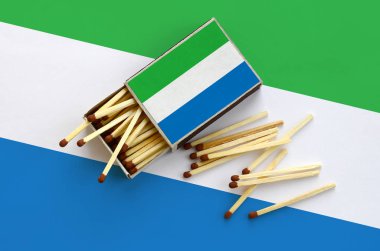 Sierra Leone bayrak bir kibrit kutusu içinden birkaç sonbahar eşleşir ve büyük bir bayrak üzerinde yatıyor açık gösterilir.