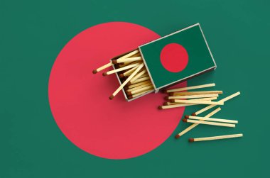 Bangladeş bayrağı bir kibrit kutusu içinden birkaç sonbahar eşleşir ve büyük bir bayrak üzerinde yatıyor açık gösterilir.