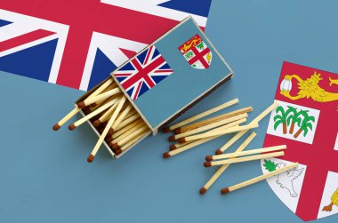 Fiji bayrak bir kibrit kutusu içinden birkaç sonbahar eşleşir ve büyük bir bayrak üzerinde yatıyor açık gösterilir.