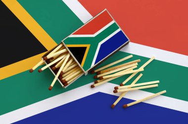 Güney Afrika bayrak bir kibrit kutusu içinden birkaç sonbahar eşleşir ve büyük bir bayrak üzerinde yatıyor açık gösterilir.