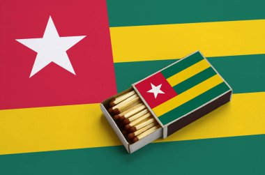 Togo bayrak açık bir kibrit kutusu içinde gösterilen hangi dolu maçlar ve büyük bir bayrak üzerinde yatıyor.