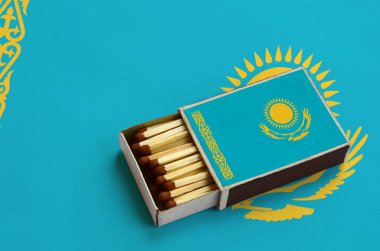 Kazakistan bayrağı açık bir kibrit kutusu içinde gösterilen hangi dolu maçlar ve büyük bir bayrak üzerinde yatıyor.