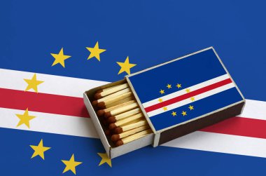 Cabo verde bayrak açık bir kibrit kutusu içinde gösterilen hangi dolu maçlar ve büyük bir bayrak üzerinde yatıyor.