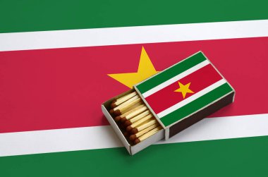 Surinam bayrak açık bir kibrit kutusu içinde gösterilen hangi dolu maçlar ve büyük bir bayrak üzerinde yatıyor.
