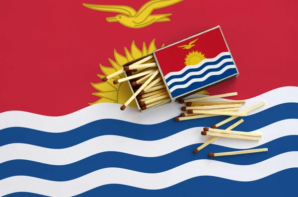 Kiribati bayrak bir kibrit kutusu içinden birkaç sonbahar eşleşir ve büyük bir bayrak üzerinde yatıyor açık gösterilir.