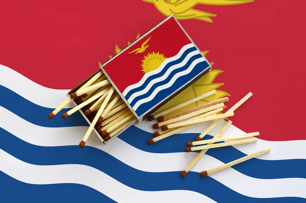 Kiribati bayrak bir kibrit kutusu içinden birkaç sonbahar eşleşir ve büyük bir bayrak üzerinde yatıyor açık gösterilir.