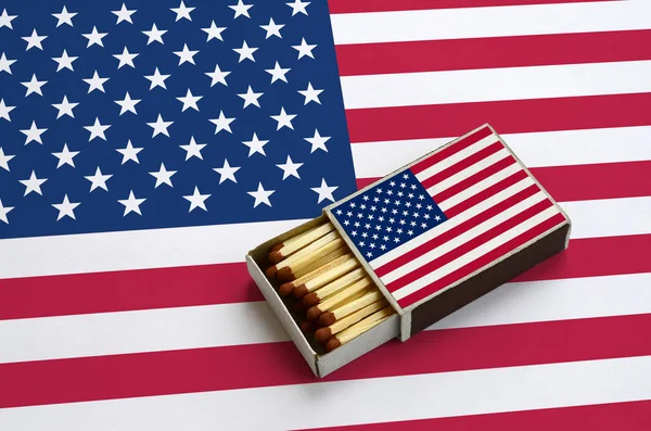 Amerika Birleşik Devletleri bayrağı açık bir kibrit kutusu içinde gösterilen hangi dolu maçlar ve büyük bir bayrak üzerinde yatıyor.