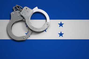 Honduras bayrağı ve polis kelepçe. Suç ve ülkenin suçlar kavramı.