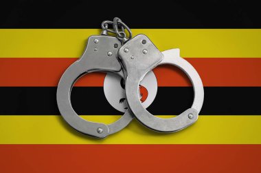 Uganda bayrağı ve polis kelepçe. Ülke ve suç karşı koruma kanununda gözetilmesi kavramı.