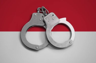 Endonezya bayrağı ve polis kelepçe. Ülke ve suç karşı koruma kanununda gözetilmesi kavramı.