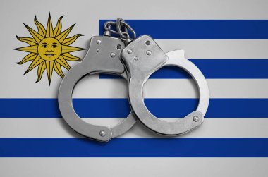 Uruguay bayrağı ve polis kelepçe. Ülke ve suç karşı koruma kanununda gözetilmesi kavramı.