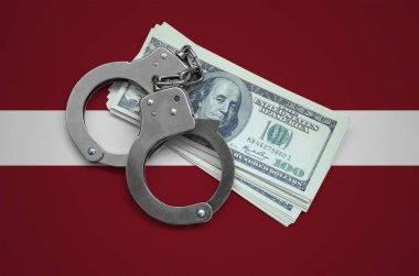 Letonya bayrağı ile kelepçe ve a bohça-in dolar. Ülkenin para birimi bozulması. Mali suçlar.