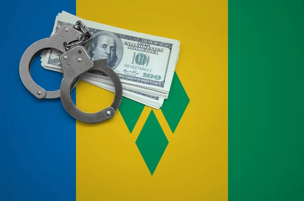 Saint Vincent and the Grenadines flag  with handcuffs and a bundle of dollars. The concept of breaking the law and thieves crimes.