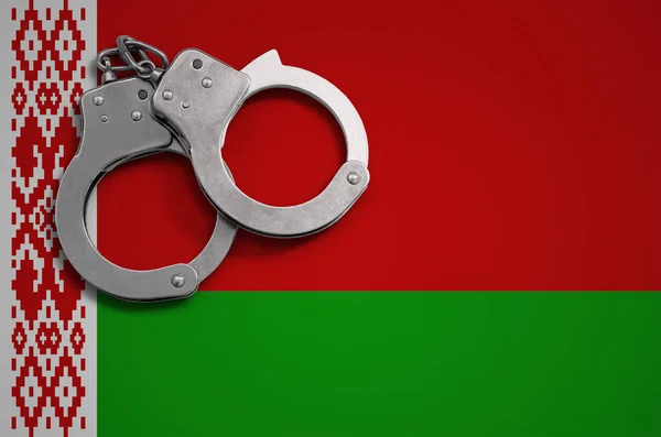 Belarus flag  and police handcuffs. The concept of crime and offenses in the country.
