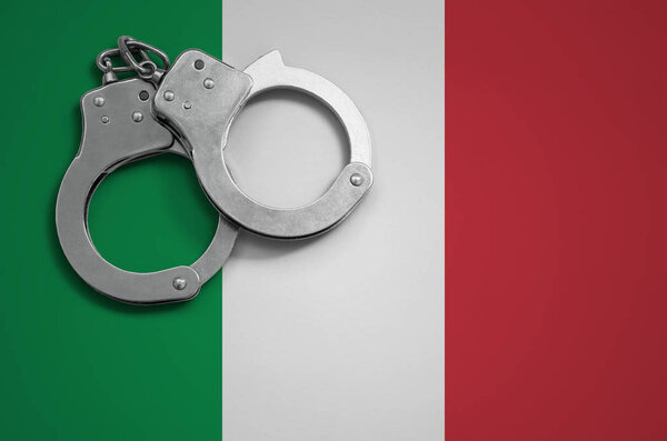 Italy flag  and police handcuffs. The concept of crime and offenses in the country.