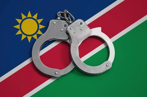 Namibia flag  and police handcuffs. The concept of observance of the law in the country and protection from crime.
