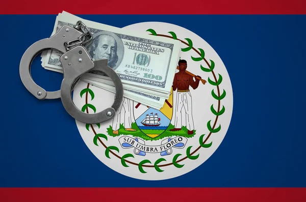 Belize flag  with handcuffs and a bundle of dollars. The concept of breaking the law and thieves crimes.