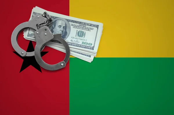 Guinea Bissau flag  with handcuffs and a bundle of dollars. The concept of breaking the law and thieves crimes.