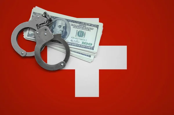 Switzerland flag  with handcuffs and a bundle of dollars. The concept of breaking the law and thieves crimes.