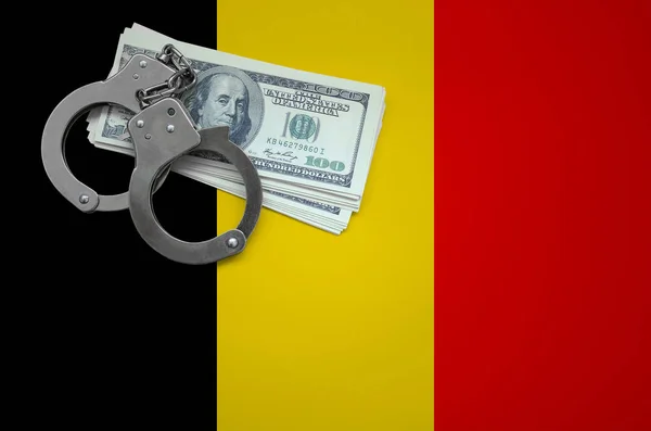 Belgium flag  with handcuffs and a bundle of dollars. The concept of breaking the law and thieves crimes.