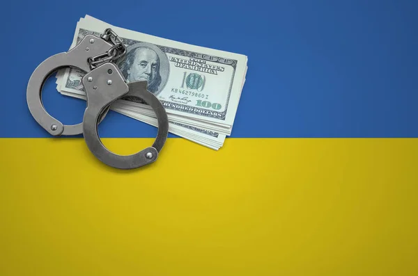 Ukraine flag  with handcuffs and a bundle of dollars. The concept of breaking the law and thieves crimes.