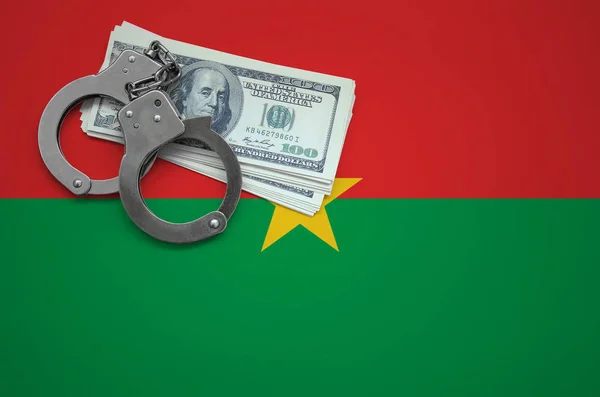 Burkina Faso flag  with handcuffs and a bundle of dollars. The concept of breaking the law and thieves crimes.