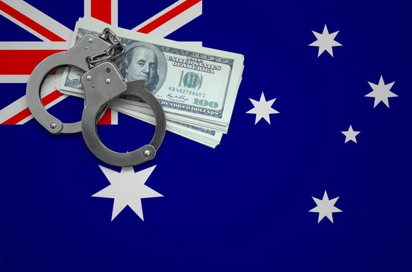 Australia flag  with handcuffs and a bundle of dollars. The concept of breaking the law and thieves crimes.