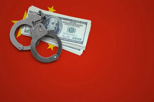 China flag  with handcuffs and a bundle of dollars. The concept of breaking the law and thieves crimes.