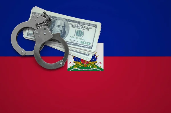 Haiti flag  with handcuffs and a bundle of dollars. The concept of breaking the law and thieves crimes.