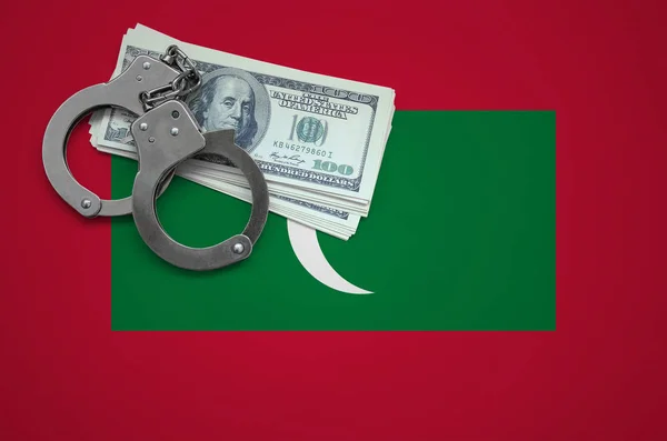 Maldives flag  with handcuffs and a bundle of dollars. The concept of breaking the law and thieves crimes.