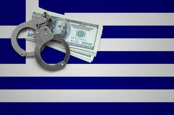 Greece flag  with handcuffs and a bundle of dollars. The concept of breaking the law and thieves crimes.