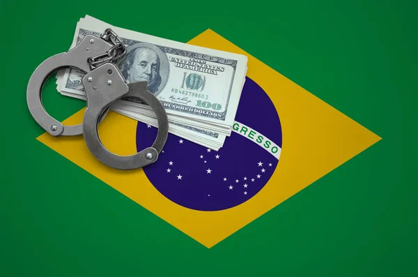 Brazil flag  with handcuffs and a bundle of dollars. The concept of breaking the law and thieves crimes.