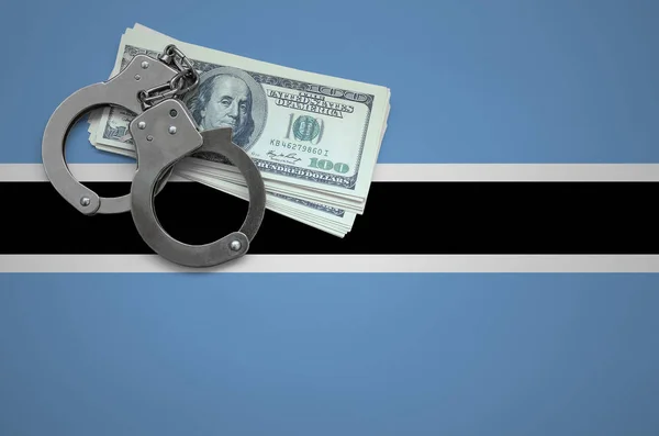 Botswana flag  with handcuffs and a bundle of dollars. The concept of breaking the law and thieves crimes.