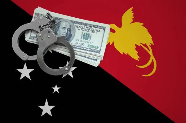Papua New Guinea flag  with handcuffs and a bundle of dollars. The concept of breaking the law and thieves crimes.