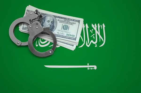 Saudi Arabia flag  with handcuffs and a bundle of dollars. The concept of breaking the law and thieves crimes.